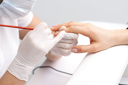 使用透明指甲油的修美师抛光女士手指皮肤治疗两个人艺术指甲保养美容图片