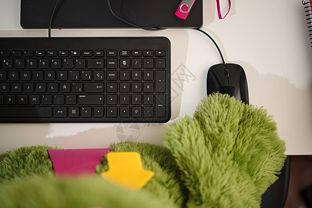 有人用电脑键盘和鼠标在现代黑智能手机旁边使用空屏幕 黑咖啡杯和暗黑木制办公桌 手电筒图片
