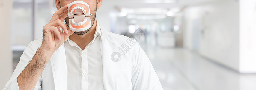 年轻男性牙医在牙科诊所工作图片