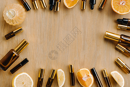 瓶子和柠檬中的必要油 木质表面的橙子木头治疗疗法滴管身体琥珀色药品液体香味化妆品图片