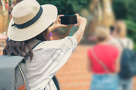 女人使用智能手机拍照 假日度假的旅行者旅游 旅行旅行概念游客女士电话自拍微笑摄影照片假期幸福女性图片