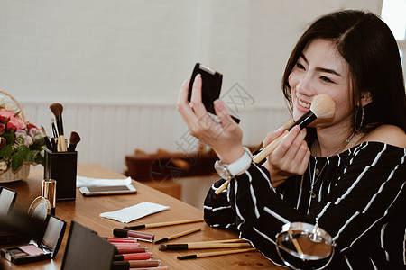 使用化妆化妆品的亚洲女性女孩刷子女士图片