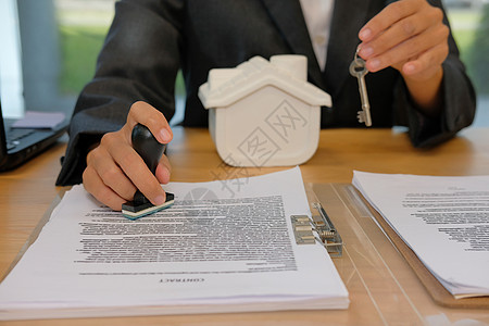在抵押贷款合同协议文件上加盖房屋钥匙的房地产经纪人文档商务桌子财产银行风险橡皮房子人士文书商业高清图片素材