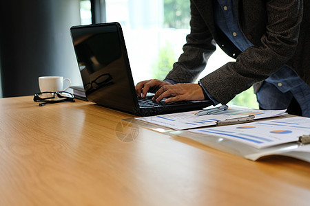 在办公室工作的人用电脑笔记本电脑键盘打字图表工人桌子女士商务职场男人职业人士技术图片