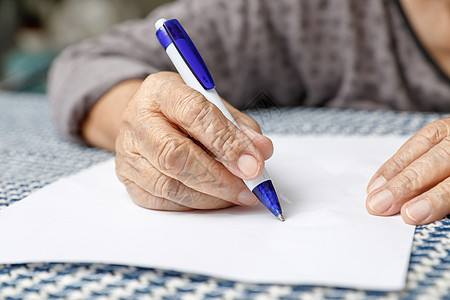 以空白纸写字的老年妇女退休煎饼皱纹铅笔桌子写作祖父母女性教育长老图片