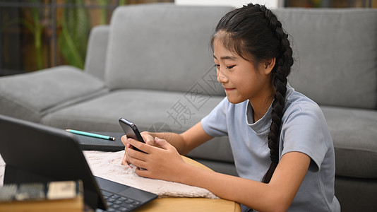 亚洲女孩在虚拟教室在线学习期间在智能手机上搜索信息 电子学习 家庭教育概念图片