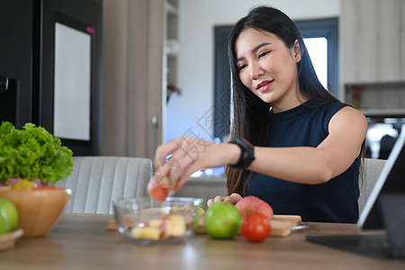 健康年轻女子在厨房里用新鲜蔬菜和水果做素食 吃素食图片