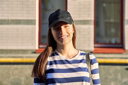 城市街道背景黑帽少女户外肖像画 黑色帽子青少年女性青春期潮人头发乐趣女孩女士棒球学生图片