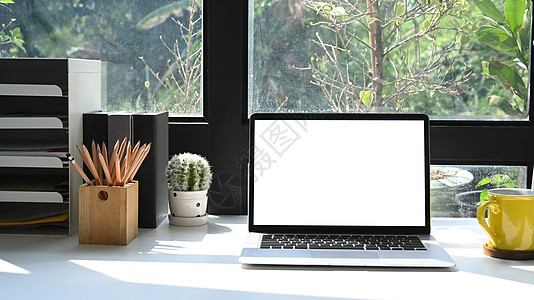 舒适的工作场所 白桌上有膝上型计算机 文具和咖啡杯图片