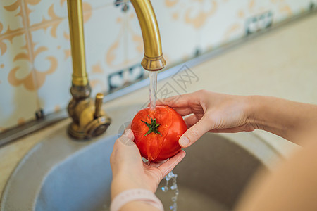 特写一个在水中洗番茄女人的管道女士蔬菜饮食龙头生态卫生飞溅沙拉指甲厨房图片