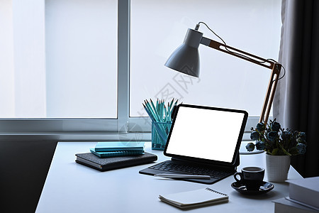 办公室办公桌 配有计算机平板电脑 灯具 花盆和文具图片