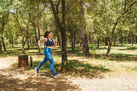 年轻的女运动员训练 在公园慢跑以保持身体健康 运动员在户外练习运动 健康和健康的生活方式图片
