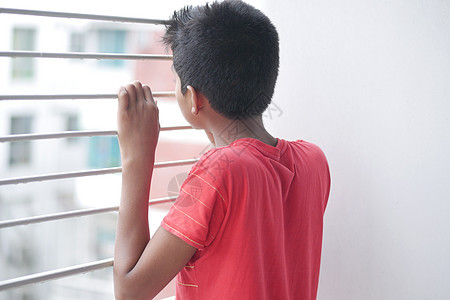 悲伤的十几岁男孩透过窗户看婴儿孩子压力孩子们手势情感孤独沮丧图片
