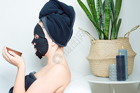 年轻女孩在用布面遮罩的美容皮上享受温泉疗养化妆品护理纺织品女士棉布保湿房子美丽核心床单背景图片