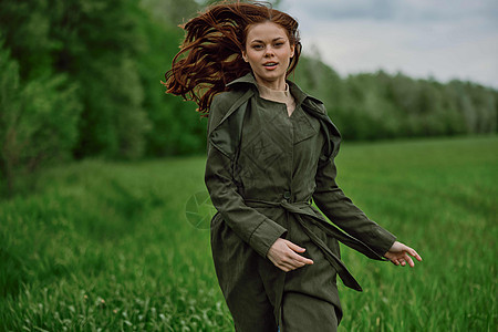 一个美丽快乐的女人 穿过一片绿地 满着红发流淌的青春 幸福的情感青少年晴天头发享受太阳乐趣天空场地跑步成人图片