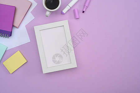 白色的空白图片框 咖啡杯和紫色背景的文具图片