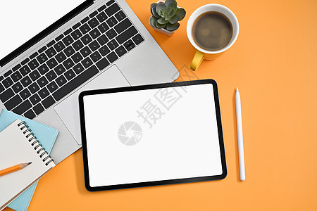 顶视图数字平板电脑 手写笔 膝上型计算机 咖啡杯和笔记本在黄色背景图片