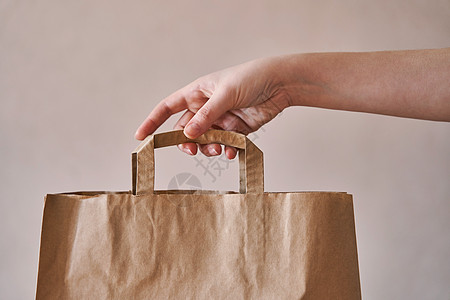 女孩拿着一个环保的纸袋女性行星商业营销女士白色消费者商品棕色零售图片