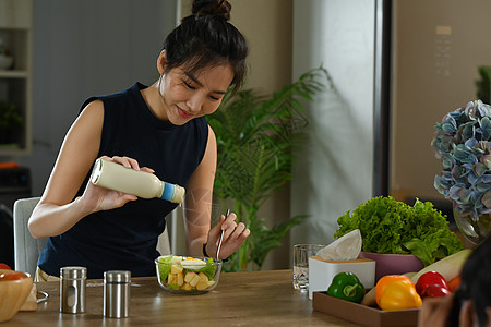 健康健康的女子在玻璃碗里撒沙拉酱 饮食和健康食品概念 (笑声)图片