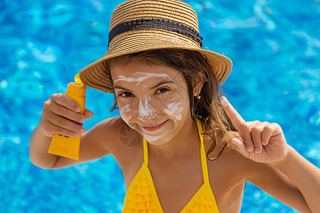 孩子脸上涂了防晒霜 有选择地集中注意力假期洗剂身体阳光护理紫外线乐趣横幅棕褐色奶油图片