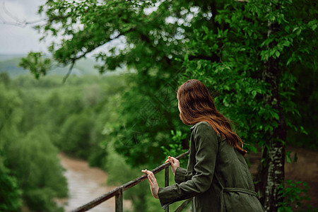 在公园中行走的红发妇女望着暴风山河 旅行 雨季照片草地丛林冒险下雨季节微笑森林女孩快乐图片