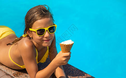 孩子在游泳池附近吃冰淇淋 有选择的焦点假期水池快乐游泳乐趣青年女孩闲暇横幅小吃图片