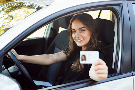 乘坐汽车并出示驾驶驾照的女驾驶员图片