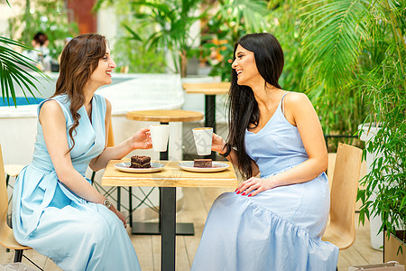 在咖啡馆用咖啡杯打女人的笑脸食堂八卦会议城市讲话餐厅快乐讨论说话女士图片