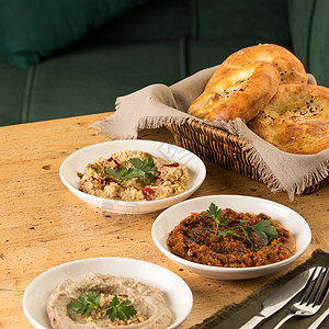 一张地中海盘子( muhammara和hummus)的照片与一篮面包图片