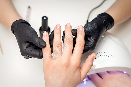 美术师握着客户手指的手化妆品治疗程序魅力奢华闲暇温泉工具抛光客厅图片