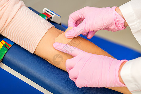 护士在手臂上涂粘贴石膏伤口考试医师女性女士医生静脉专家捐款实验室图片