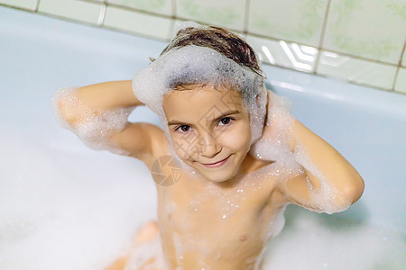 孩子在浴缸肥皂水里洗澡 有选择的焦点头发幸福女性卫生婴儿肥皂气泡游泳洗发水童年图片