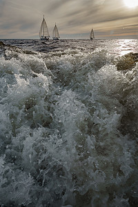 冲洗船在前景地的浮水 日落时航游艇背景 帆 Regatta号 大浪竞赛海浪追求帆船赛巡航全景戏剧性天空气泡阳光图片