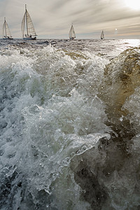 冲洗船在前景地的浮水 日落时航游艇背景 帆 Regatta号 大浪地平线天空海浪航行戏剧性阳光天气太阳巡航竞赛图片