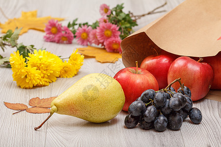 梨子 葡萄和红苹果 木制桌上有纸袋养分团体食物包装餐巾小路饮食宏观水果叶子图片