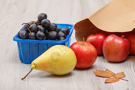 梨子 葡萄和红苹果 木制桌上有纸袋养分叶子饮食水果团体宏观食物餐巾小路包装图片