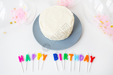 多彩的蜡烛与生日快乐的信 孤立在白色背景上 还有面粉蛋糕和便当蛋糕 假日和惊喜概念图片
