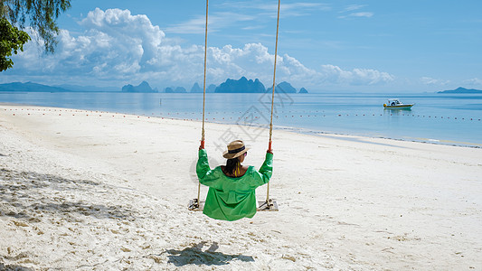 泰国普吉岛附近热带岛屿纳卡岛海滩上的女人 海滩上荡秋千的女人幸福蜜月天堂太阳镜女士女性夫妻太阳旅行约会图片