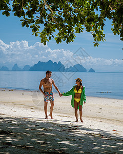 泰国普吉岛附近热带岛屿纳卡岛海滩上的一对男女 海滩秋千上的女人和散步的男人海洋假期太阳镜约会女士旅行女性晴天幸福中岛图片
