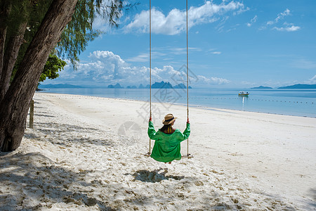 泰国普吉岛附近热带岛屿纳卡岛海滩上的女人 海滩上荡秋千的女人夫妻约会假期太阳自由女士中岛男人天堂蜜月图片