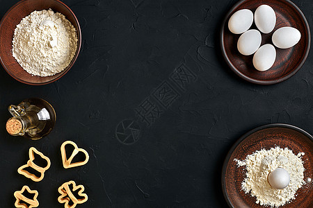 面粉 鸡蛋 滚针 塑料烘烤形式 顶视图 黑桌上饼干木头食物美食滚动产品小麦厨房糕点勺子图片