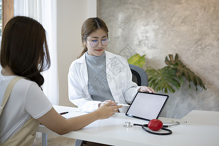 女医生持有数字平板电脑 在医院向病人显示阳性检测结果的女医生图片