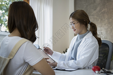 持有数字片片片和在医院向病人显示阳性检测结果的女医生; 在医院图片