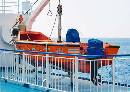 海上船只甲板上的橙色救生艇图片