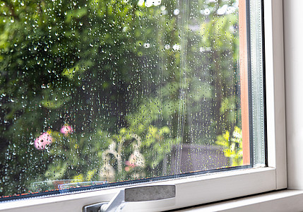 夏天雨天从窗户到花园的景色 窗玻璃上有雨滴 (掌声)图片