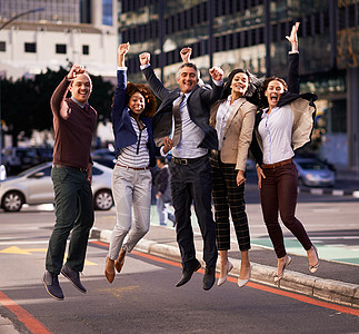 梦幻团队的又一场胜利 一群商务人士在城市中兴奋地跳跃了起来图片