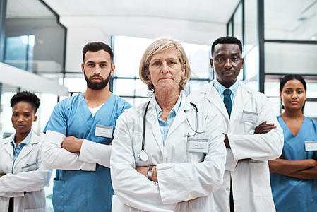 我们的目标是提高医疗保健的质量和有效性 一群医生站在医院里的肖像图片