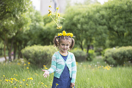 小孩在绿色草地上玩耍 小女孩扔花朵图片