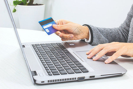 妇女用信用卡和笔记本电脑在网上支付一笔费用图片