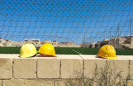 建筑工地墙上挂着黄硬帽子图片